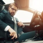 Businessman fastening seatbelt before driving